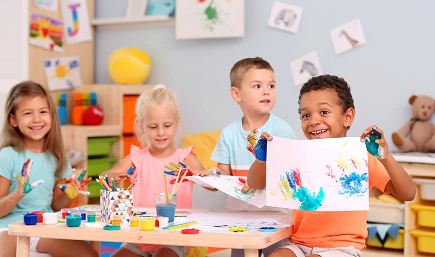 Kinder bemalen ihre Hände mit Fingerfarbe und stempeln sie auf Papier, Foto: Africa Studio/Shutterstock Kinder bemalen ihre Hände mit Fingerfarbe und stempeln sie auf Papier